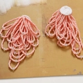 Elegant pink bead flower earrings with crystal tassels on a natural textured background - Pink