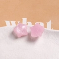 Detail of pink jelly pentagram charms with silver glitter on white textured porcelain - Pink
