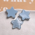 Macro shot of resin star charms in macaron blue and glitter finishes for DIY crafts - Blue