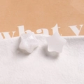 Macro detail of star-shaped resin studs with silver glitter on white textured plate - White