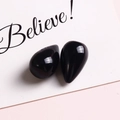 Close-up of elegant polished black teardrop charms with mirror-like finish for jewelry making - Black