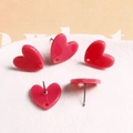 Macro-opname van felroze hartvormige acryl oorbellen met uitgesneden detail en metalen pin - Hart Roosrood