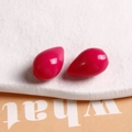 Detail of high-gloss rose red teardrop resin charms on a textured stone display - Rose Red