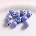 Detailed view of light blue glossy ceramic cat paw beads for DIY handmade jewelry crafts - Blue and Purple