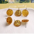Vue macro détaillée des boucles d'oreilles en résine pailletée dorée avec feuille d'argent - Particules Brillantes Jaune Vif
