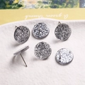 Gros plan de clous d'oreilles ronds argentés pailletés pour création de bijoux DIY - Particules Brillantes Gris Blanc