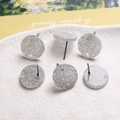Détail macro de clous d'oreilles ronds argentés pailletés avec trous pour bijoux DIY - Particules Brillantes Gris Argent