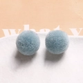 Detail view of two soft 20mm light blue plush pom-pom balls for DIY jewelry and crafts - Light Blue