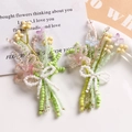 Detail of handmade beaded flower bouquet accessory with pastel pearls and white bow - Green