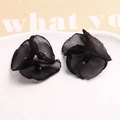 Detail of 3D black mesh flower earrings with gold bead center on a white plate - Black Three-petal Flower