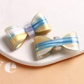 Détail d'accessoires de nœud pour cheveux en acétate coloré sur support en pierre blanche - Bleu-Jaune