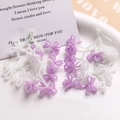 Close-up of handmade beaded flower tassels in purple and white for DIY earring jewelry - White + Purple