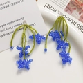 Handgemaakte kralen oorbellen met groene stengel en blauwe kristallen bloemen - 1 Stuk / Blauw