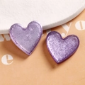 Macro shot of purple glitter resin heart charms for DIY jewelry and hair accessories - Purple Heart