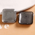 Dettaglio macro di ciondoli quadrati in resina con foglia d'argento e trama screpolata - Quadrato Grigio Lucido