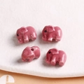 Detailed view of four pink ceramic elephant beads with glossy glaze for DIY jewelry making - 1 Piece / Rose Red
