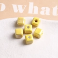 Macro shot of 9mm bright yellow glossy ceramic cube beads for DIY jewelry making - 1 Piece / Yellow