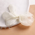 Macro detail of creamy white tulle bow showing delicate mesh texture and airy fabric - Off-white