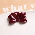 Macro shot of glossy burgundy resin flower charm for jewelry making on ceramic plate - Dark Red