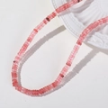 Makrodetail von 6 mm rosa Erdbeerquarz Perlen in Scheibenform auf Keramikteller - 1 Stück / Wassermelonen Quarz