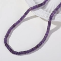 Detail von 6 mm lila Wassermelonen-Kristallperlen auf einem eleganten Keramikteller - 1 Stück / Amethyst