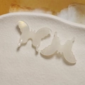 Macro view of creamy white 3D butterfly acetate charms with pearlescent finish - White