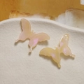 Detail of gradient acetate butterfly charms with pearlescent finish on ceramic tray - Orange
