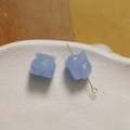 Dettaglio macro di perline a forma di gatto in polvere di conchiglia con perni per gioielli - Blu