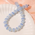 Detail of 13mm round glass beads with blue feather texture on a ceramic dish - 1 Piece / Blue