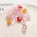 Detailed macro of handmade floral beaded charm with pink faceted teardrop pendant - Pink