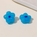 Macro detail of blue resin flower charms with dark centers for DIY jewelry making - Blue
