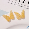 Close-up of butterfly acetate charms with yellow marble texture on white plate - Yellow Marble Pattern (B03-3-14-28) / Yellow