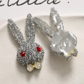 Macro detail of French style rabbit head patch with silver rhinestones and gold bow - Silver