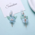 Details von blauen Blumen-Haarnadeln mit Golddrahtwicklung und grünen Blattakzenten - Blau