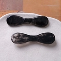 Close-up of elegant hair clips with black and white ink-washed marble texture in a ceramic dish - Black