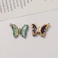Makroaufnahme von Schmetterlingsanhänger mit Farbverlauf und Goldbasis für DIY-Schmuck - Irisierendes Blaugrün