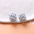 Macro shot of light blue faceted beads and white pearls hand-woven into a spherical earring - Gray