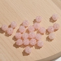 Macro-opname van roze kraalhangers in de vorm van bessen op een lichte houten basis - 1 Stuk / Roze