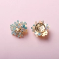 Detailed macro of iridescent floral charms with multi-layered petals and gold metal base - Iridescent Champagne