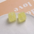 Vue détaillée de perles cubes en résine jaune texturée avec accent perle sur plateau - Jaune