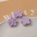 Macro view of light purple resin flower charms with a flat back for DIY crafts - Purple