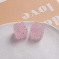 Gros plan de perles cubes de sucre roses de 16mm en résine granulée sur une assiette - Rose Clair