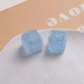 Détail de cubes en résine sucrée bleu clair de 16mm sur un plat en céramique blanc - Bleu clair