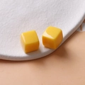 Vue macro de perles cubes en résine jaune brillant 14mm pour création de bijoux DIY - Jaune