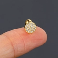 Macro shot of gold-plated stud earring with micro-paved zircons and screw ball back - Gold