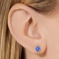 Pendientes de circonita azul oscuro en forma de pera con borde dorado en la modelo - Pendientes de botón