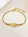 Detailopname van de gouden letter H bedel op een roestvrijstalen vierkante schakelarmband - Goud H
