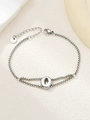 Detailopname van een zilveren roestvrijstalen armband met een gepolijste letter Q als hanger - Zilver Q