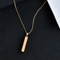 Macro shot of minimalist gold rectangular bar pendant necklace on black display - 4x30mm / Rose Gold