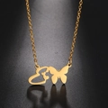Detailed view of a gold butterfly and heart pendant on a chain with reflection - Gold Letter E